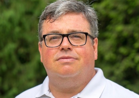 a man wearing glasses in a white button down shirt