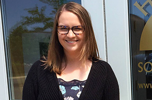 a women wearing glasses and a black cardigan with short brown hair