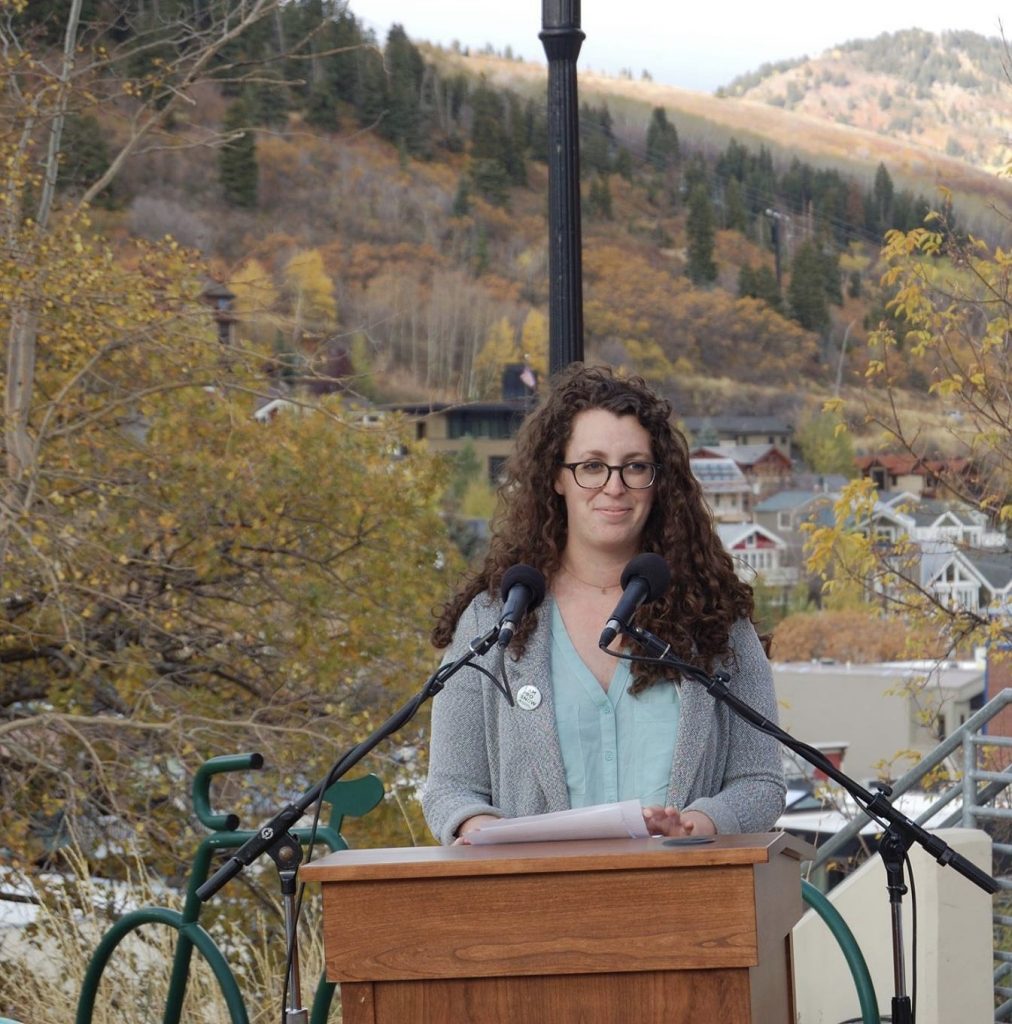 a girl with curly hair talking into microphones 