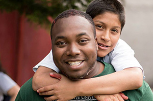 man with child wrapping his arms on his shoulders