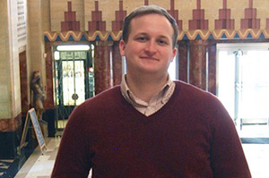 man with a red sweater smiling at the camera