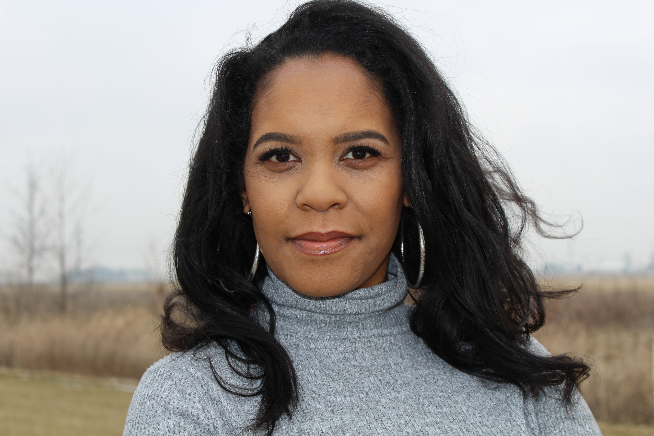 woman wearing a gray top smiling at the camera