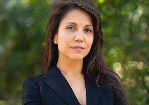 a women with long hair wearing a dress with a black blazer