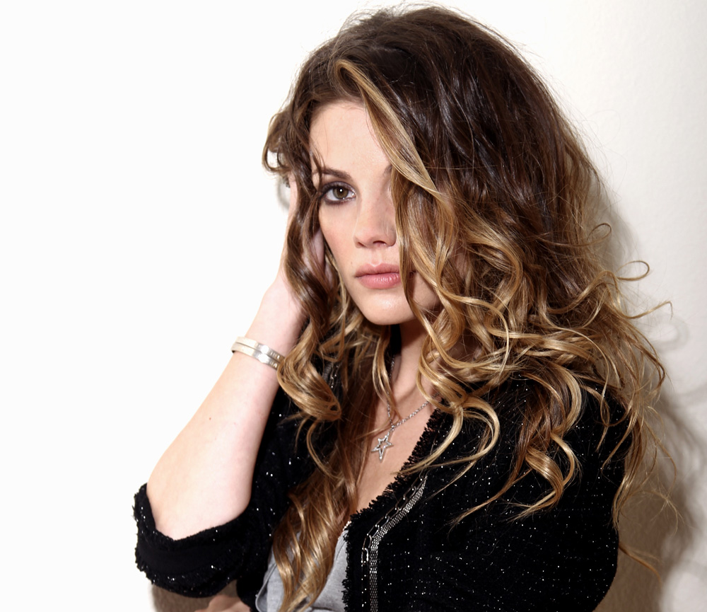 brunette woman posing for camera against a white background