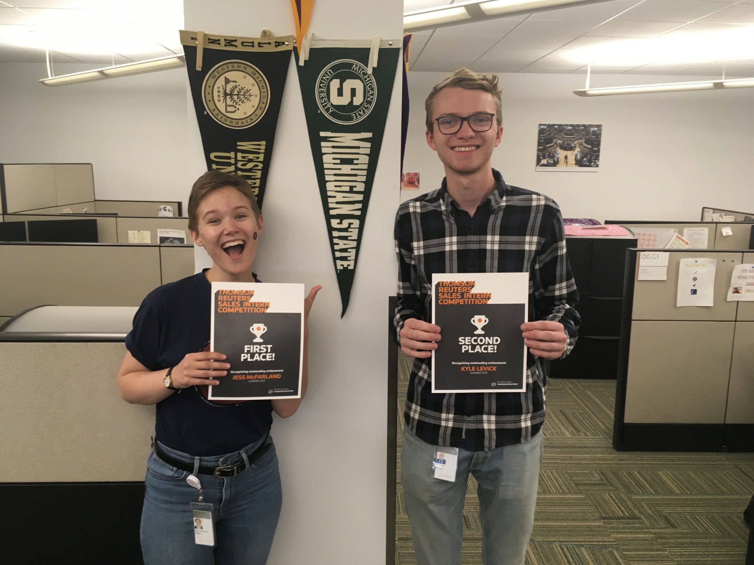 two students standing next to each other holder awards
