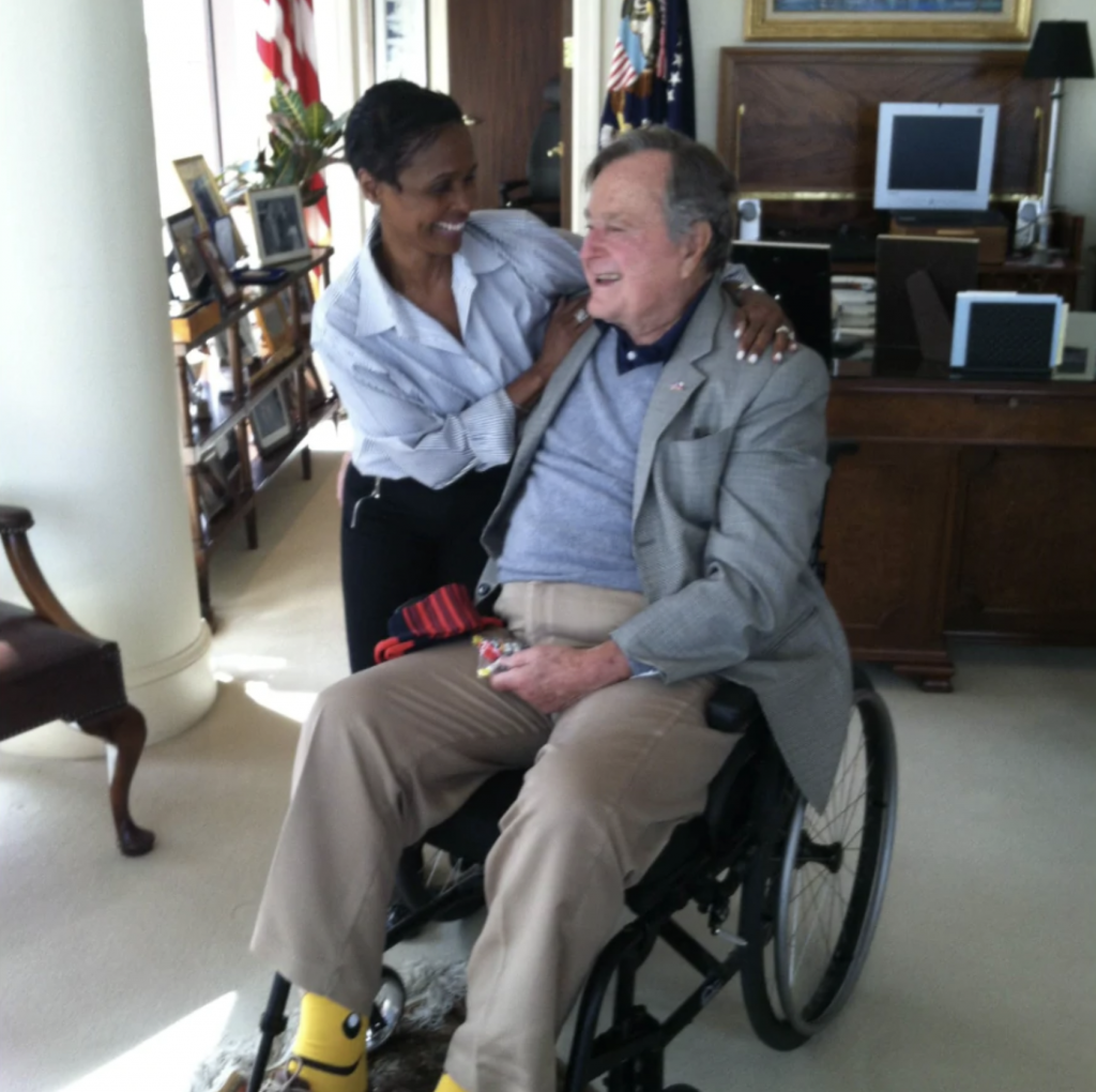 man in wheelchair who is smiling at woman who is leaning down next to him