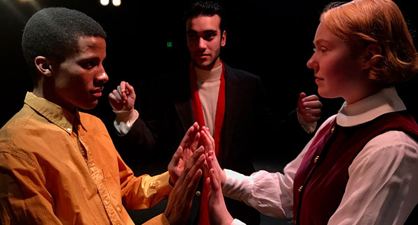 three performers in a dark theater, 2 men and 1 woman