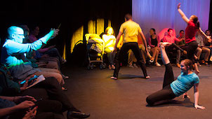 Photo of a stage with several people doing multiple different kinds of dances.