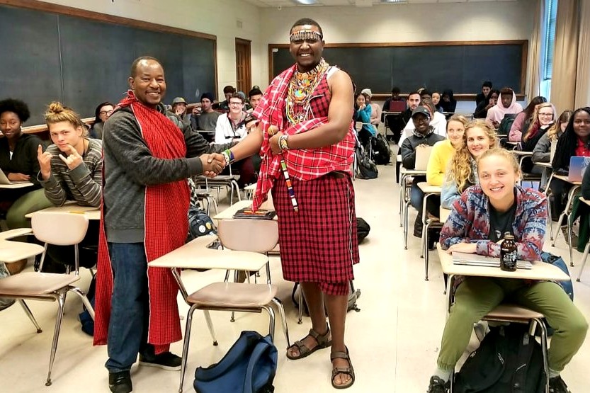 Associate Professor Jonathan Choti with guest speaker Symone Masiaine of the Maasai community of Kenya during Choti’s class. Masiaine is dressed in traditional clothing from Maasai while Choti is wearing a piece of clothing from this culture.