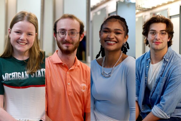 A composite portrait of four students in a brightly lit dressing room with mirrors in the background. From left to right: a student in a dark green Michigan State t-shirt layered over a white corset-style costume piece, smiling; a student in an orange collared shirt with glasses and a short beard; a student in a light blue fitted top with silver jewelry and a white skirt, smiling; and a student in glasses, a white t-shirt, and a light denim button-down shirt.