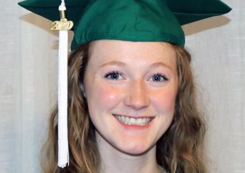 a girl in a green cap and gown with long blonde hair