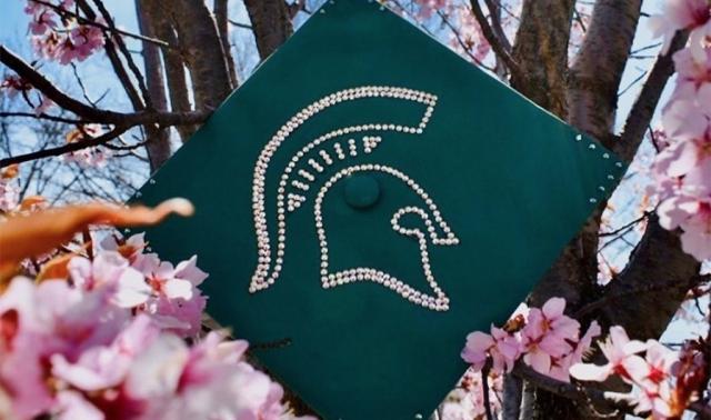 a green graduation cap with a spartan head on it