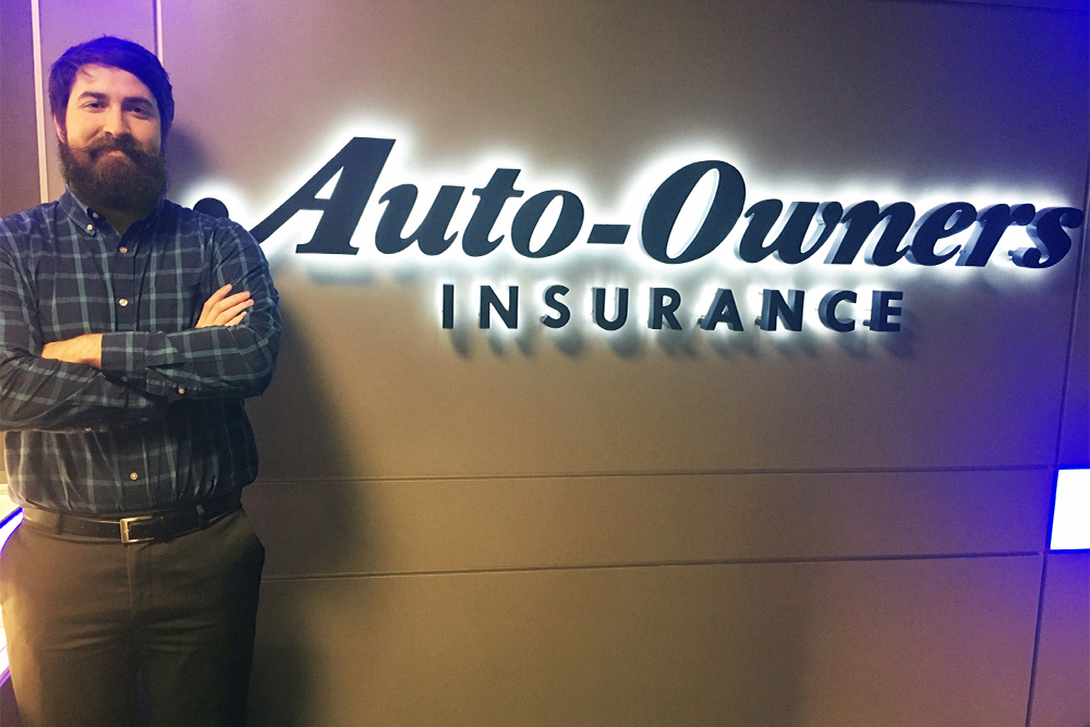 Man with brown hair standing by the Auto-Owners Insurance