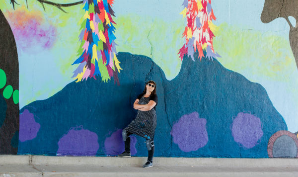 Woman with brown hair against a mural