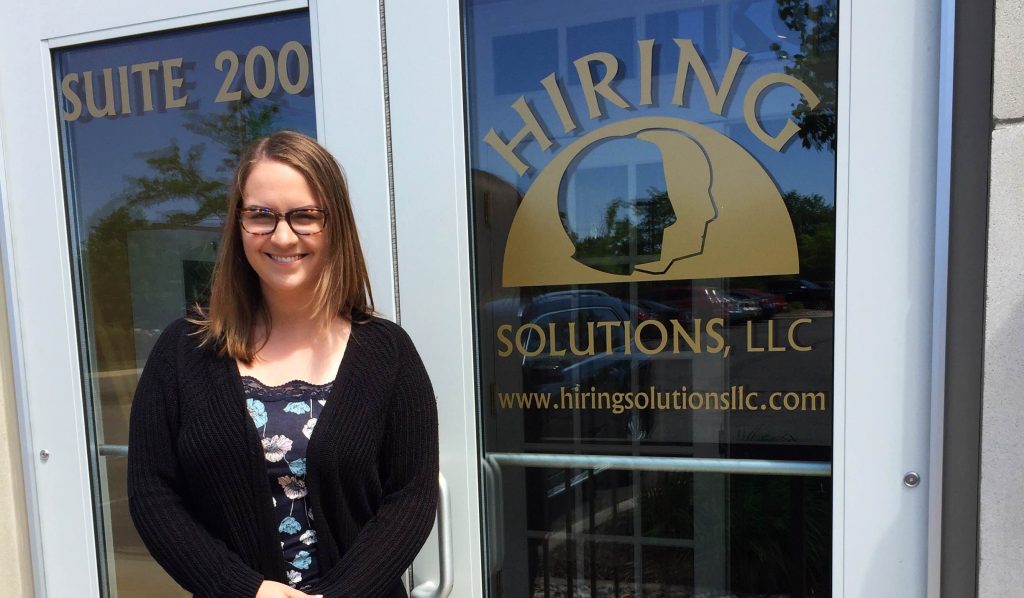 Sierra Santia in front of Hiring Solutions LLC sign