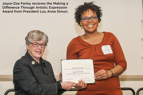 two woman both wearing glasses, one giving the other an award
