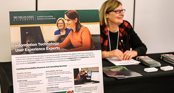 image of a woman sitting at a tables of resources at the conference