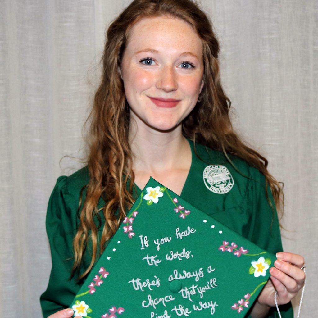 girl with blonde hair wearing green cap and gown