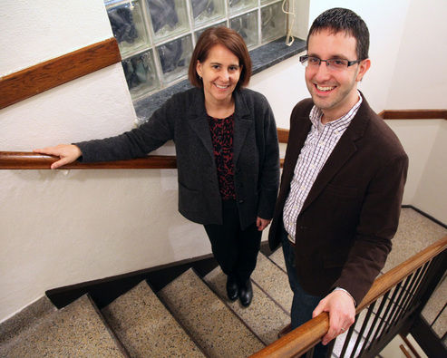 a man and woman standing on a stair case