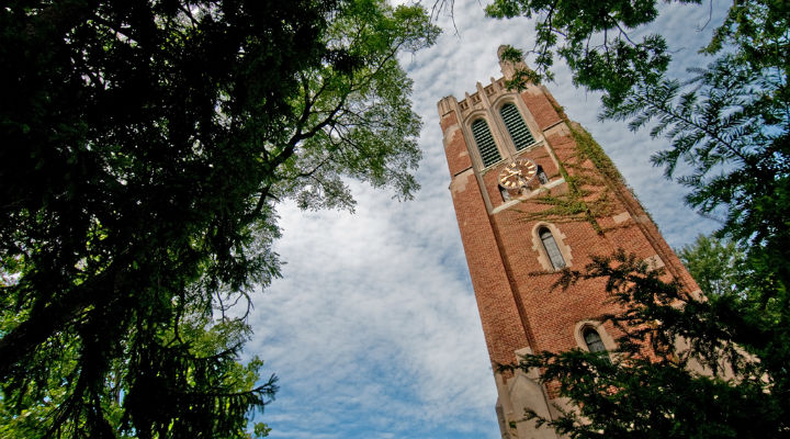 brick tower surrounded by trees with green leaves