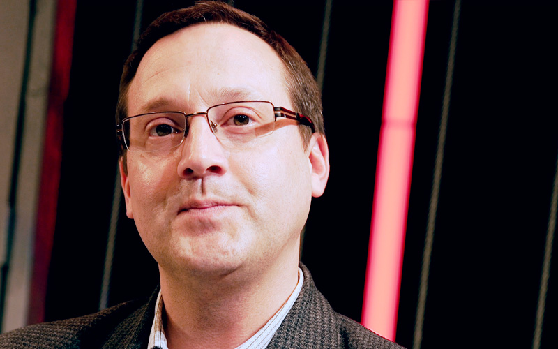 Portrait of a man wearing glasses with a red light in the background
