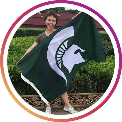 a girl holding the MSU flag