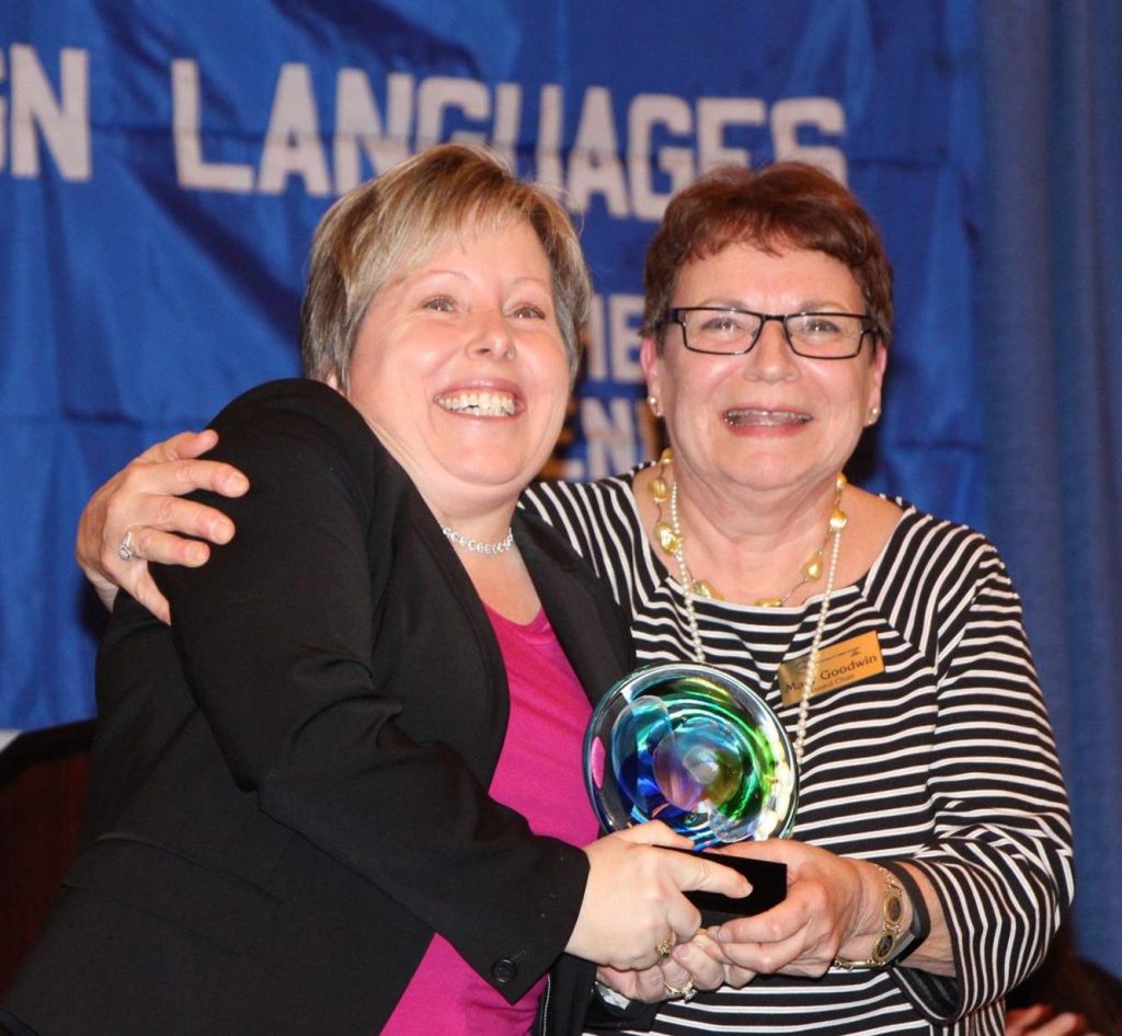 two women smiling holding award