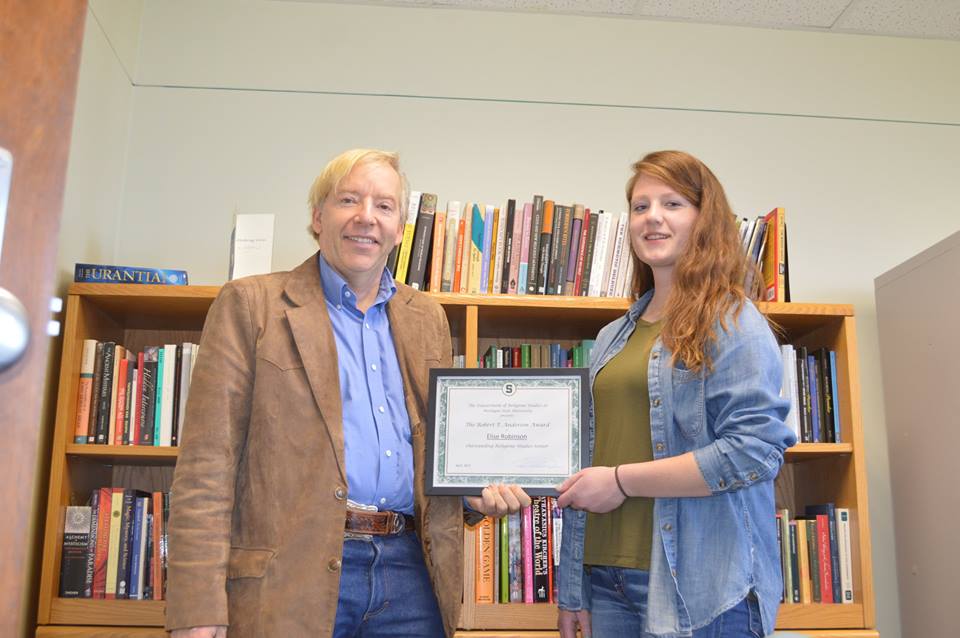 woman with red hair receiving award from man with blonde hair