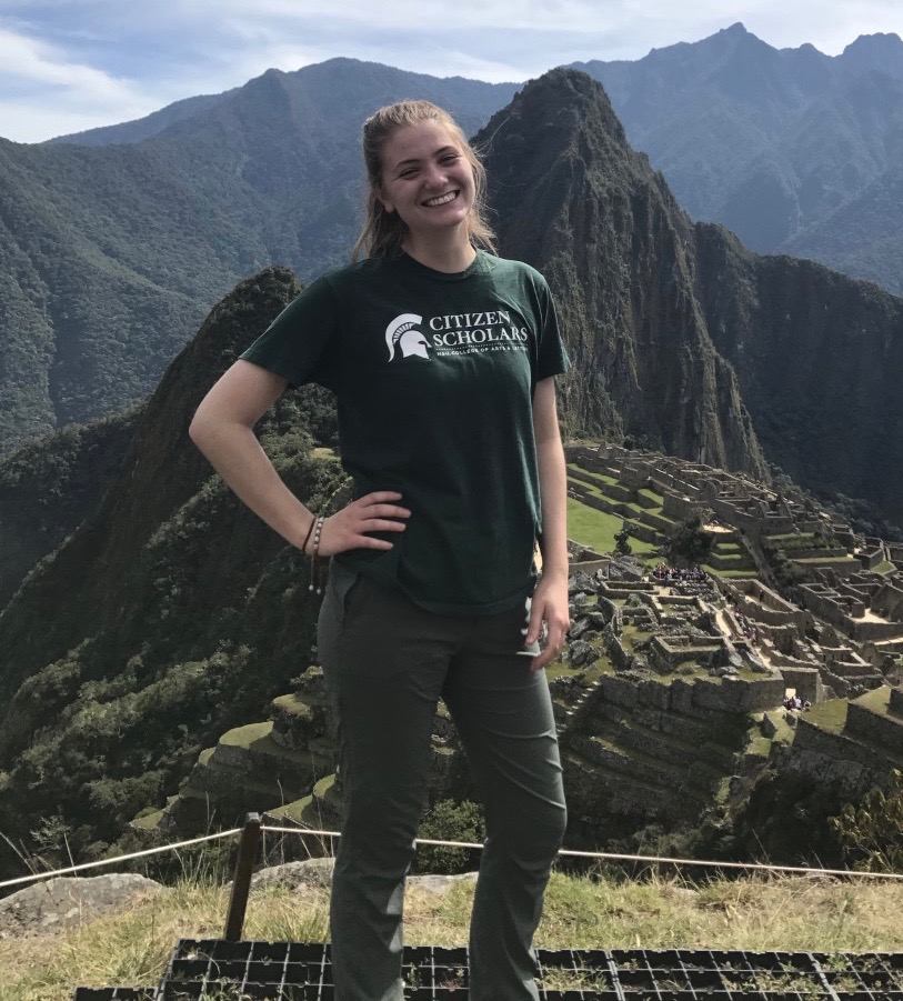 a photo of a girl in a green shirt on a mountain