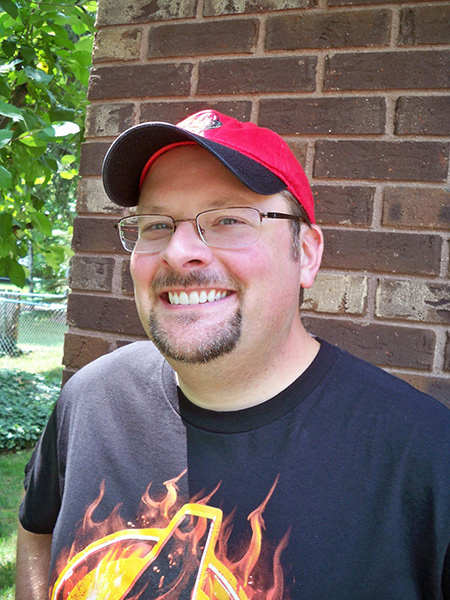 a man in a red hat wearing glasses and a black shirt 