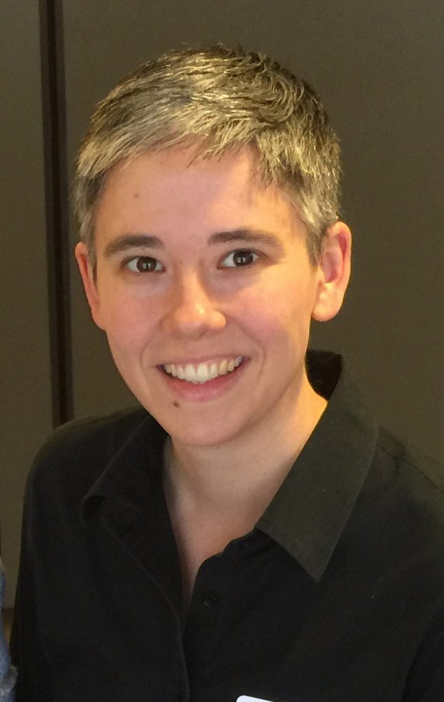 person with short hair wearing a black button up 