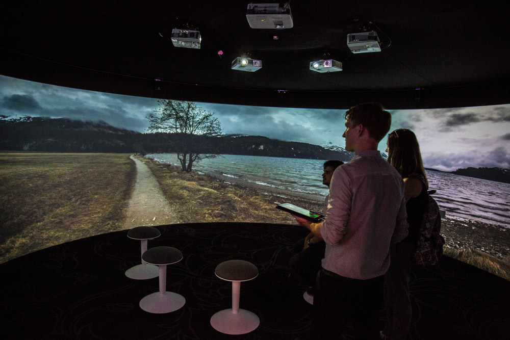 3 people stand in immersive 360 projector room