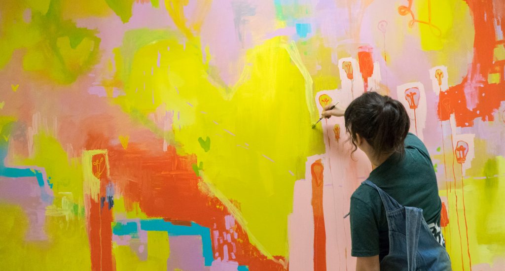a girl painting a mural
