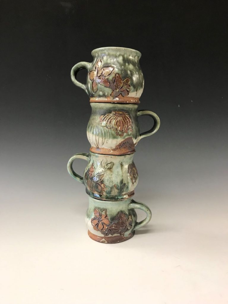 three green and brown mugs stacked on top of one another