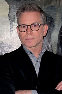 a man wearing glasses and a black suit jacket 