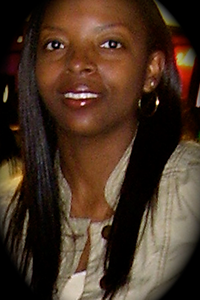 a women with long hair wearing hoop earrings and a tan jacket 