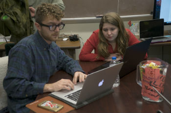 man and woman working next to each other on laptops