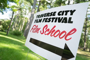 sign that says "traverse city film festival film school" with an arrow to the right