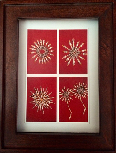 brown frame with red and white art work in the middle 