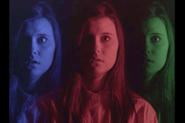 amorphous movie poster: image of a woman repeated three times horizontally in blue then red then green
