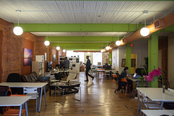 photo of an office setting with white tables and brick walls