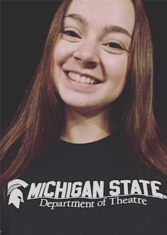 picture of a woman with long brown hair and wearing a green 'michigan state department of theatre' shirt