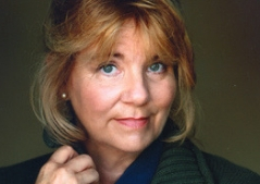 Woman with blonde hair wearing a green sweater
