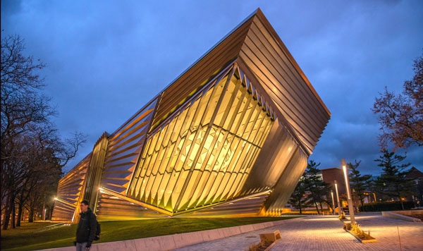 Metal building with geometric architecture lit up at night