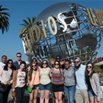 group of students standing in front of the universal studios globe