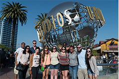 group of students standing in front of the universal studios globe