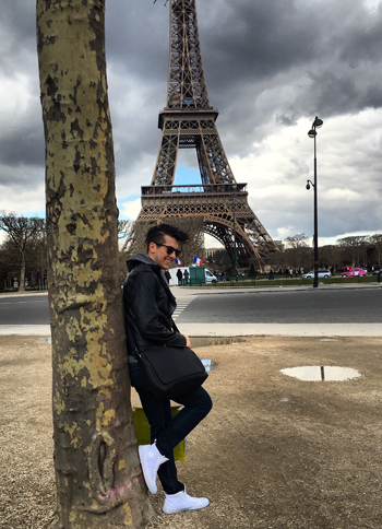a man leaning against a tree with the Eiffel tower