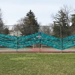 Photo of teal ribbon art installation on chain link fence