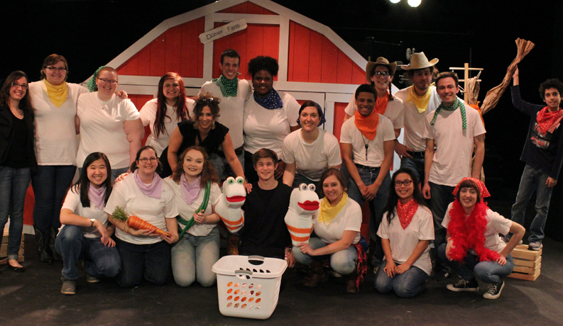 group standing on a stage in front of a fake barn 
