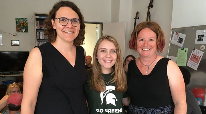 three women; two with short hair wearing black shirts and one with long hair wearing a spartan green shirt